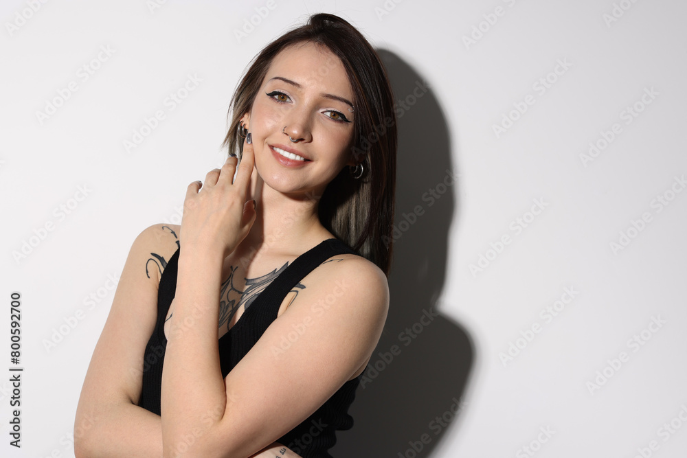 Portrait of smiling tattooed woman on light background Portrait of smiling tattooed woman on light background