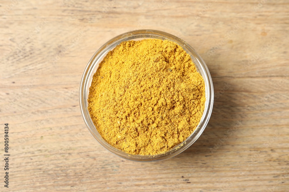 Curry powder in bowl on wooden table, top view Curry powder in bowl on wooden table, top view