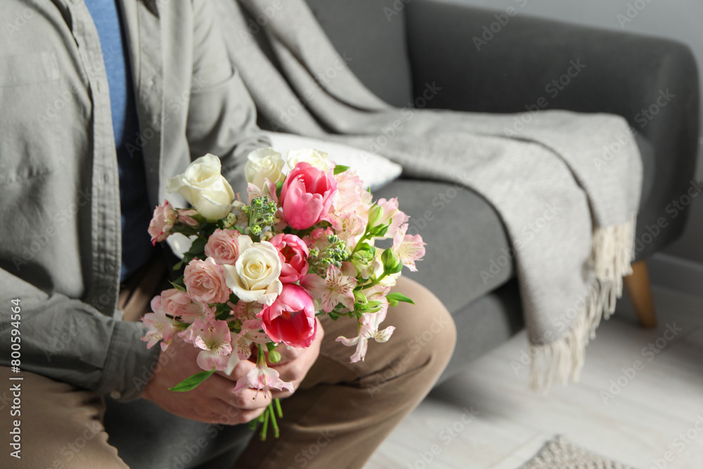 Man holding bouquet of beautiful flowers indoors, closeup Man holding bouquet of beautiful flowers indoors, closeup