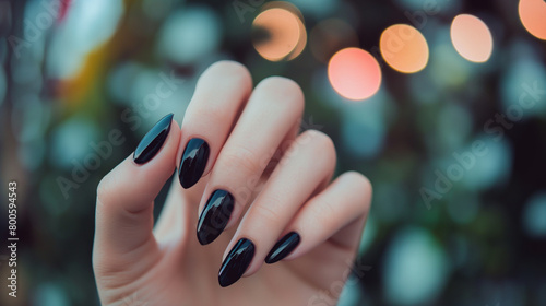 Mão de uma mulher com as unhas pintadas de preto