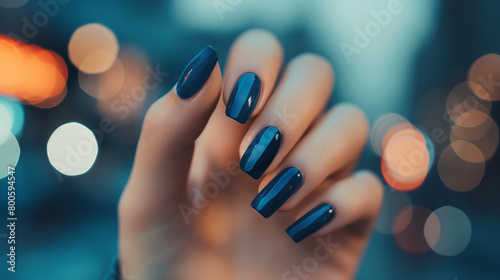 Mão de uma mulher com as unhas pintadas de azul escuro photo