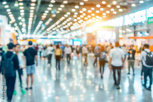 A busy expo hall with people walking around, defocused, blurred background