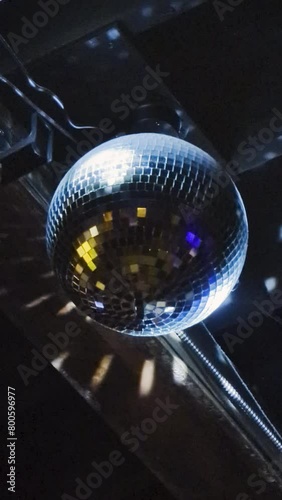 Low angle footage of mirror disco ball rotating on ceiling in nightclub