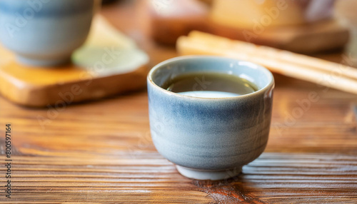Close-up of sake in ceramic cups on wooden table. National Japanese alcohol drink. Tasty beverage.