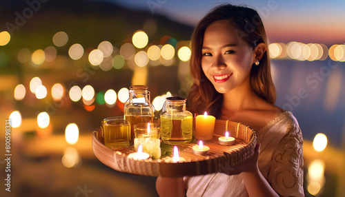 Bella ragazza thailandese porta olii essenziali per un massaggio rilassante, luci sullo sfondo. photo