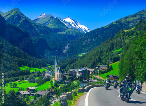 Heiligenblut village and church in Austria Alps with motorcycles driving on road