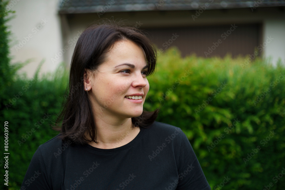 Portrait of a smiling young woman in the garden on a sunny day