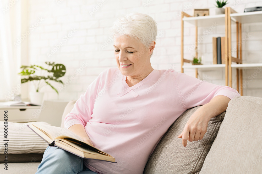 Smiling senior woman reading book at home Smiling senior woman reading book at home