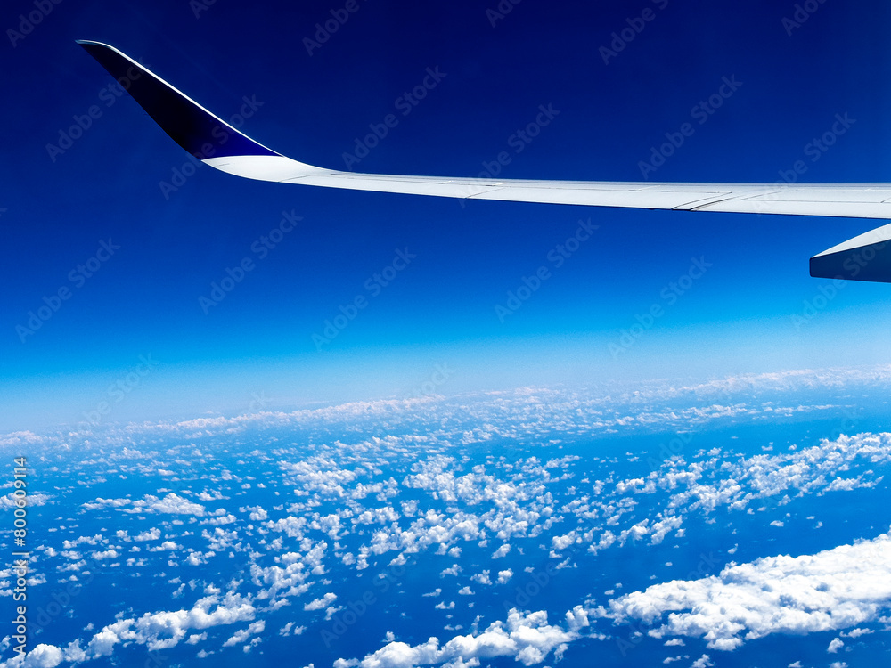 Fototapeta premium Wing of an airplane seen from the window flying over the Atlantic Ocean, on a vacation trip to the Caribbean, more specifically to Cancun (Mexico) on a direct flight from Madrid (Spain).