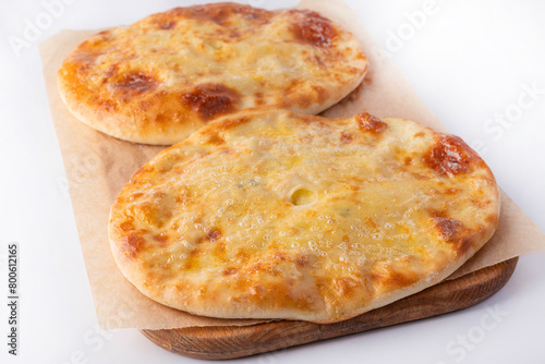 Homemade Ossetian pies on a wooden board on a white background. Homemade food concept.