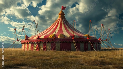 Vintage circus tent in an open field with dramatic clouds