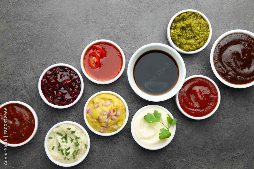 Different tasty sauces in bowls on grey table, flat lay Different tasty sauces in bowls on grey table, flat lay
