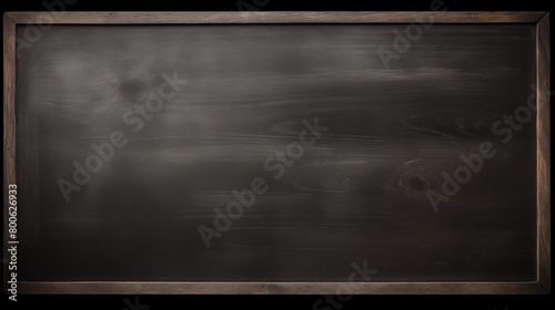 An empty blackboard with a wooden frame mounted on a wall photo