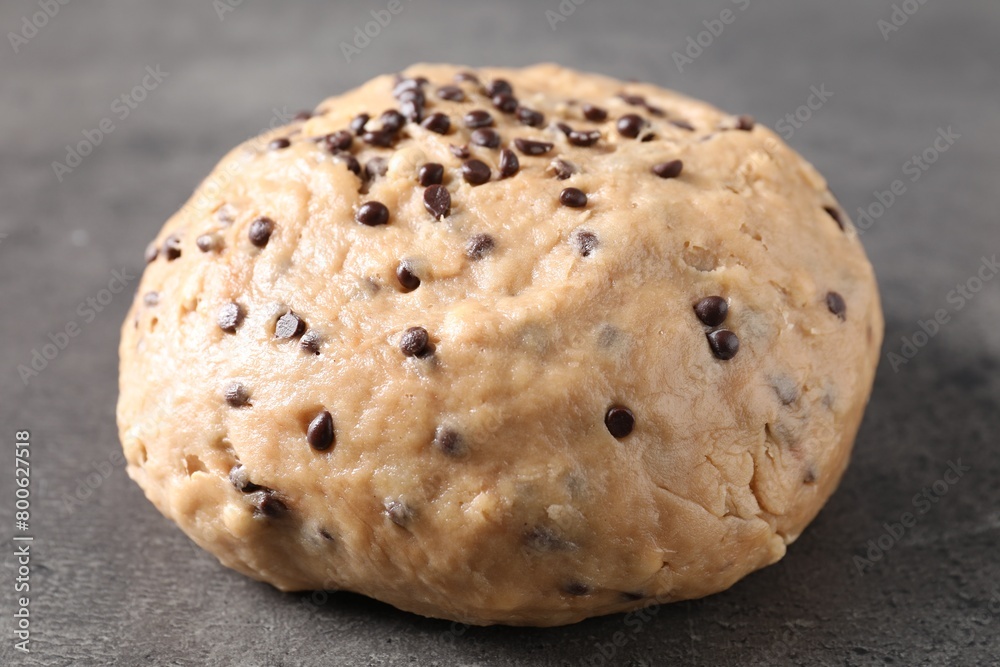Raw dough with chocolate chips on grey table, closeup Raw dough with chocolate chips on grey table, closeup