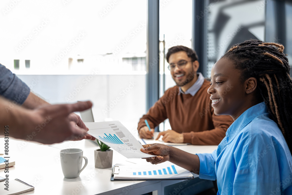 Obraz premium Diverse colleagues gather in boardroom brainstorm discuss financial statistics