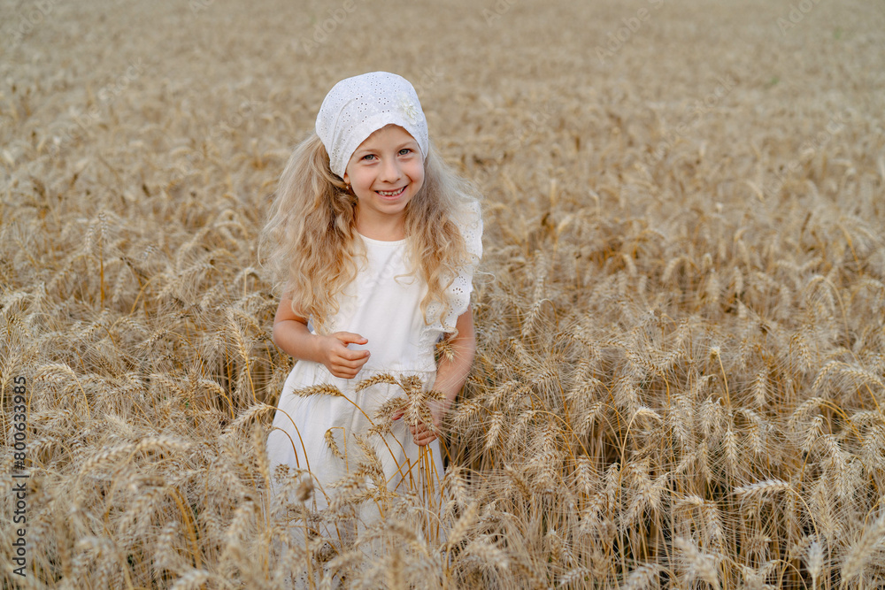 Little beautiful blonde girl with rye bread in a field of ears of rye Little beautiful blonde girl with rye bread in a field of ears of rye