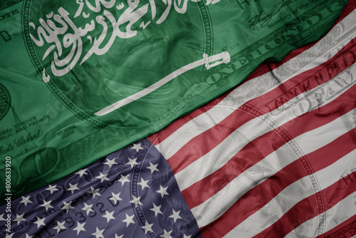 waving colorful flag of united states of america and national flag of saudi arabia on the dollar money background. finance concept. © luzitanija