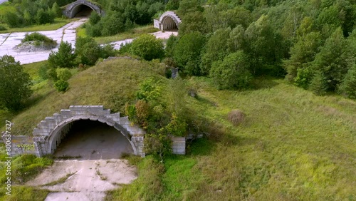 Estonia, Haapsalu-July 21, 2019: The trees and green lawn on the derelict abandoned hangar in Haapsula Estonia with the aerial view of the tunnels. The camera moves slowly backwards. photo