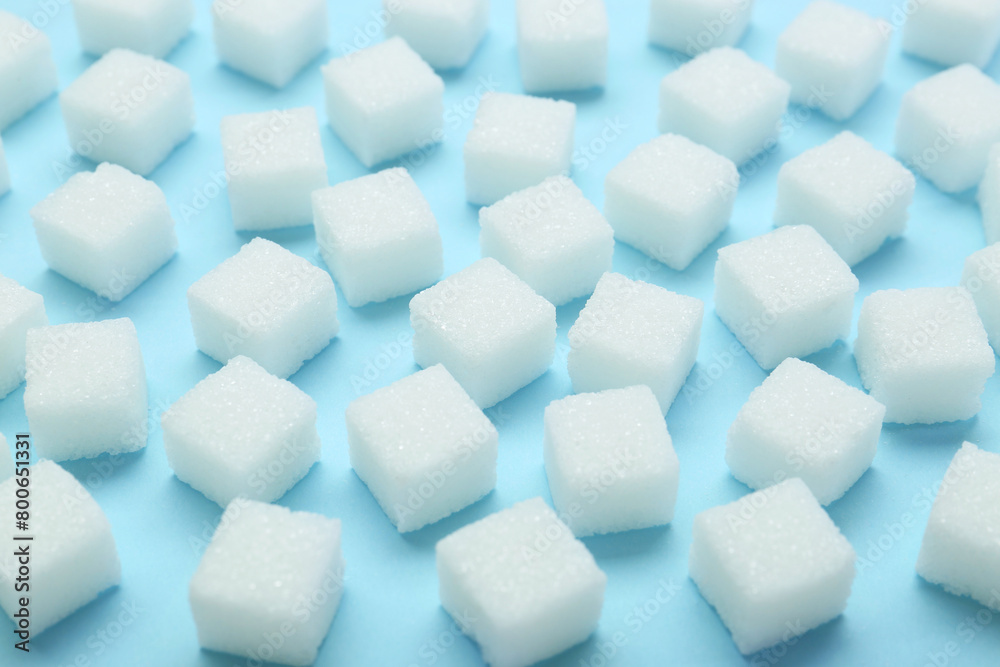White sugar cubes on light blue background, closeup White sugar cubes on light blue background, closeup