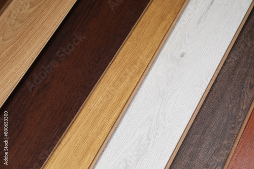 Different samples of wooden flooring as background, flat lay