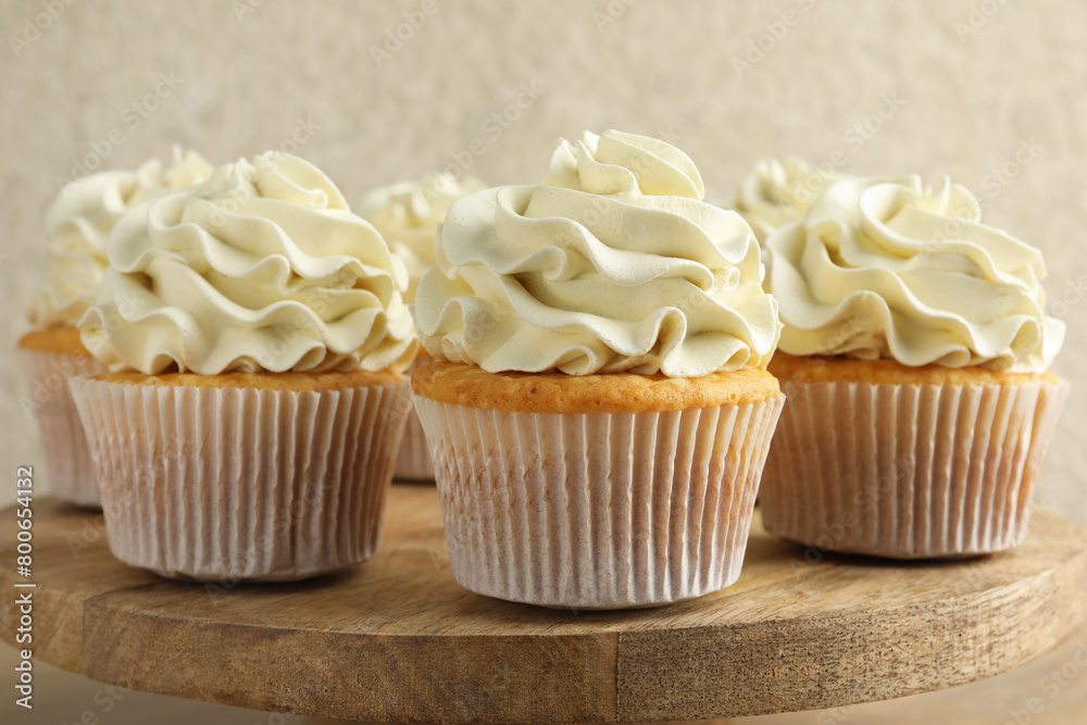 Tasty vanilla cupcakes with cream on table, closeup Tasty vanilla cupcakes with cream on table, closeup