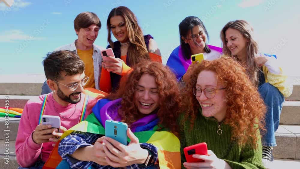 Diverse young LGBT friends using smartphone together outdoors. Communication and LGBTI community concept. Diverse young LGBT friends using smartphone together outdoors. Communication and LGBTI community concept.