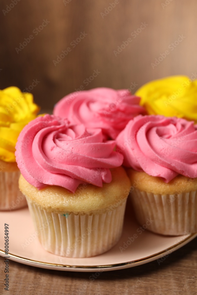 Delicious cupcakes with bright cream on table, closeup