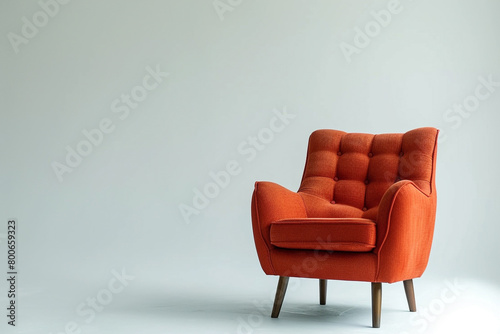 A contemporary armchair in a bold and eye-catching color, placed on a solid white backdrop. © Usama