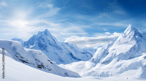 Panoramic view of snowy mountains and blue sky with white clouds