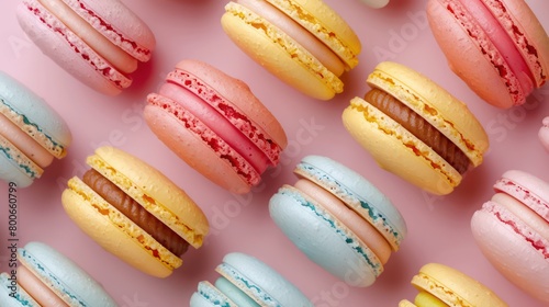 colorful macarons arranged in a light pink background