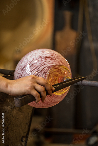 Closeup of person glassmaking in hot shop