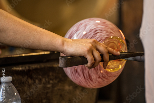 Closeup of person glassmaking in hot shop photo