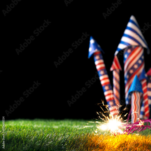4th of July bottle rockets or fireworks in USA colors of red, white, and blue with lit sparkling fuse for patriotic US American 4th of July celebration. © Leigh Prather