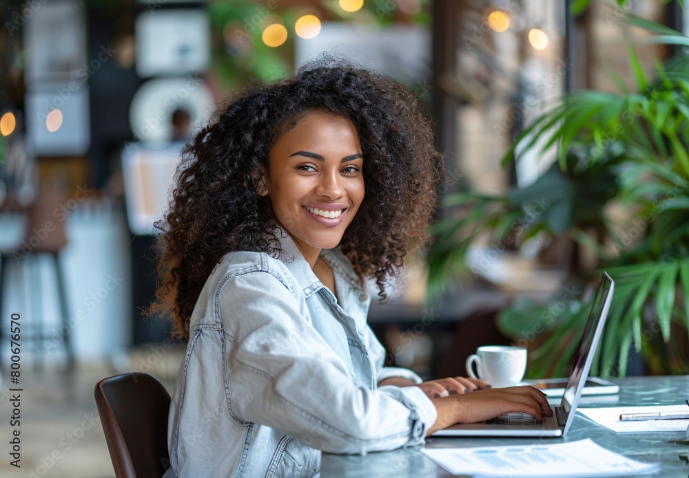 a young smiling businesswoman working on her laptop in an office a young smiling businesswoman working on her laptop in an office