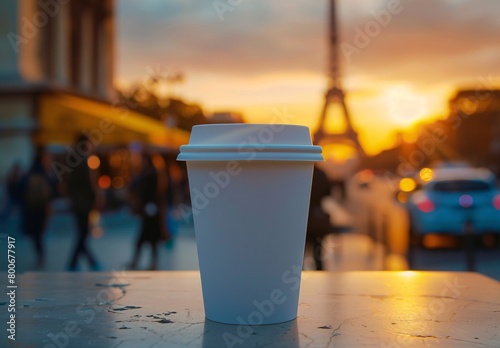 A white paper coffee cup with a plastic lid stands on a the eiffel tower in paris photo