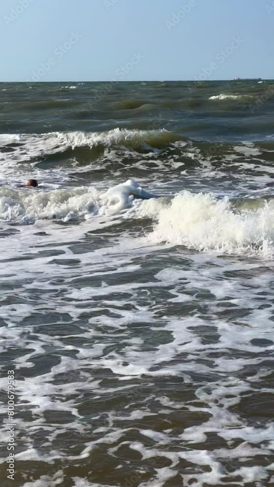 A child swims in the Sea of Azov. A boy jumps into the sea waves from the beach. The boy dives into the foaming wave. The delight of a child from a vacation at the sea. Happy moments with children. 4K A child swims in the Sea of Azov. A boy jumps into the sea waves from the beach. The boy dives into the foaming wave. The delight of a child from a vacation at the sea. Happy moments with children. 4K