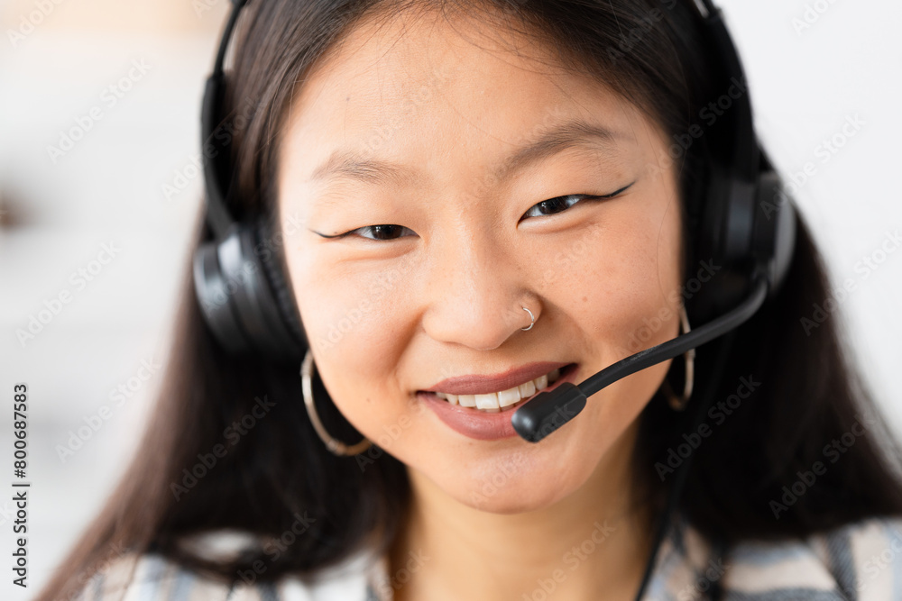 Close-up portrait of a chinese teleoperator smiling while working form home Close-up portrait of a chinese teleoperator smiling while working form home
