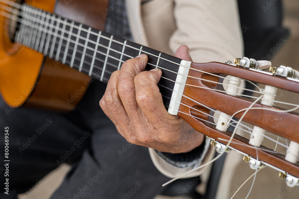 Fototapeta premium details of a musical chord on a guitar, hands of a person playing instruments with strings, classical music, object and lifestyle wallpaper
