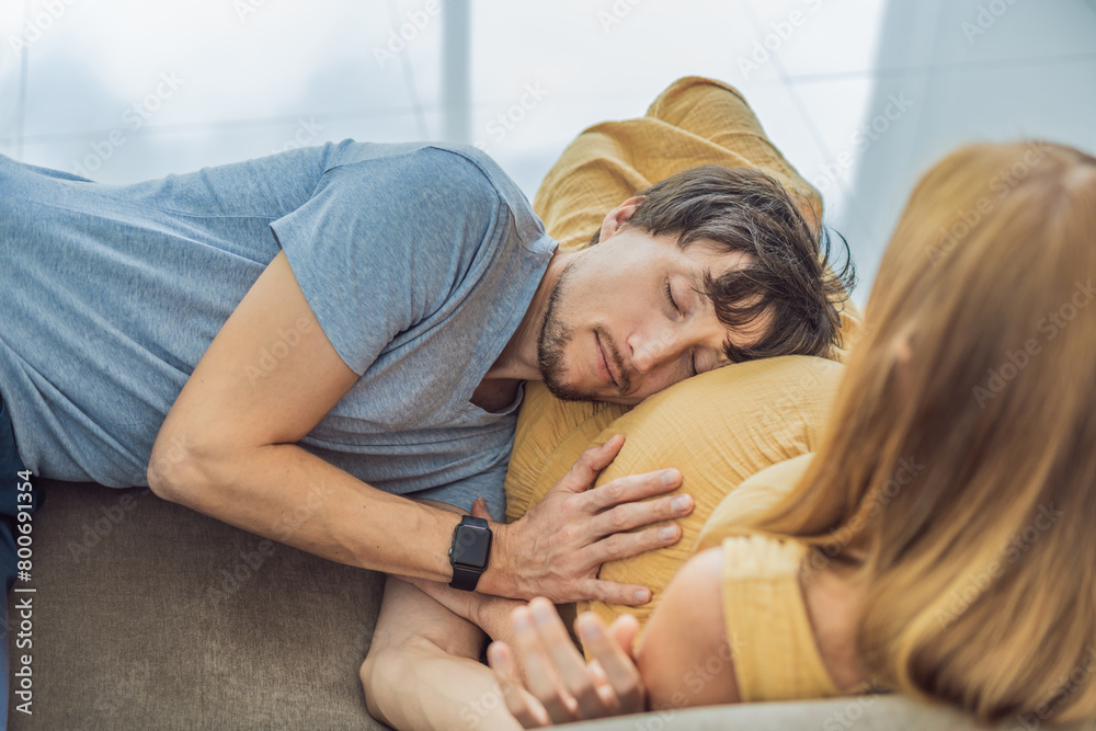 Tender moment as husband lovingly embraces his pregnant wife's belly while they lie together on the sofa, sharing warmth and anticipation Tender moment as husband lovingly embraces his pregnant wife's belly while they lie together on the sofa, sharing warmth and anticipation
