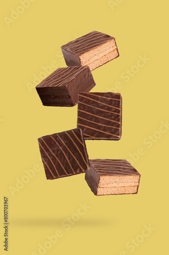 Falling layer cake with chocolate on yellow background.