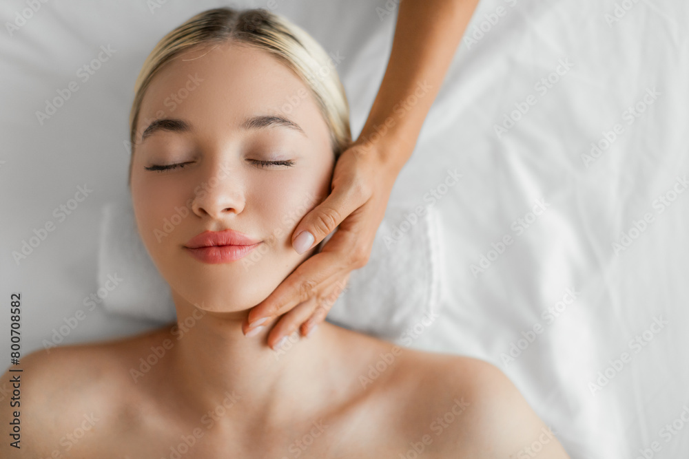 Young Woman Enjoying a Relaxing Neck Massage at Serene Spa
