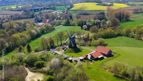 Aerial drone view of ancient windmill with agricultural fields in background in German countryside