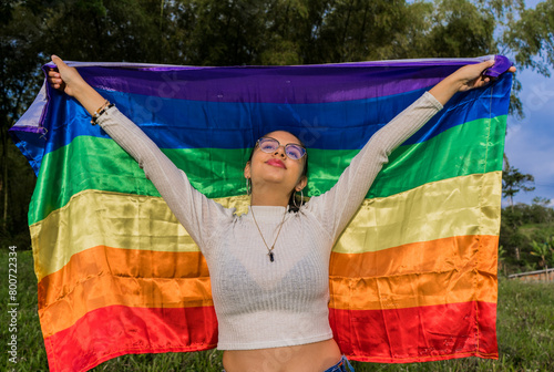 joven mujer con la bandera de la cultura gay al aire libre