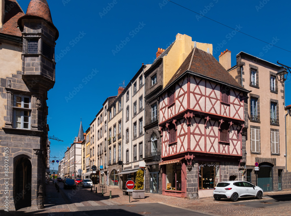 Street of French town and commune Riom during daytime. View of vintage half-timbered houses.
