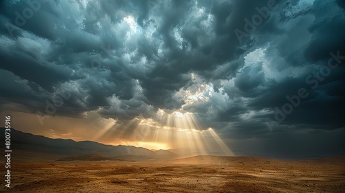 Dramatic cloudscape over vast desert terrain - A captivating cloudscape with sun rays bursting through dark storm clouds, illuminating a sprawling desert below photo