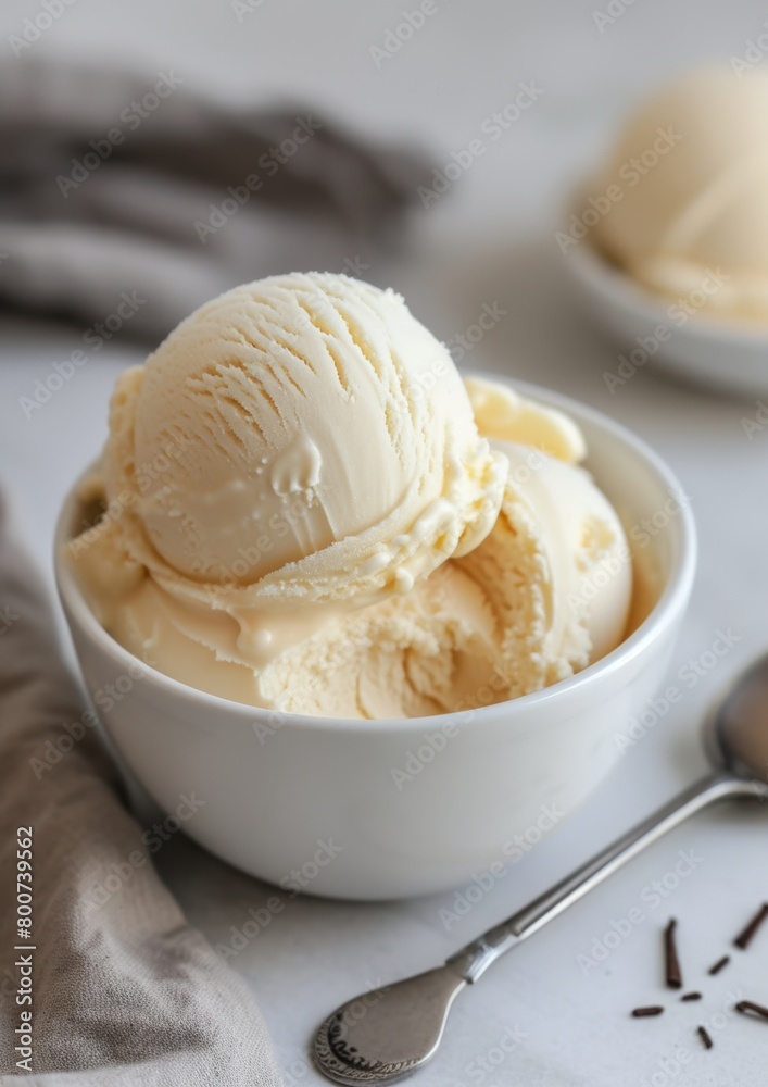 White bowl with vanilla ice cream scoops, light background. White bowl with vanilla ice cream scoops, light background.