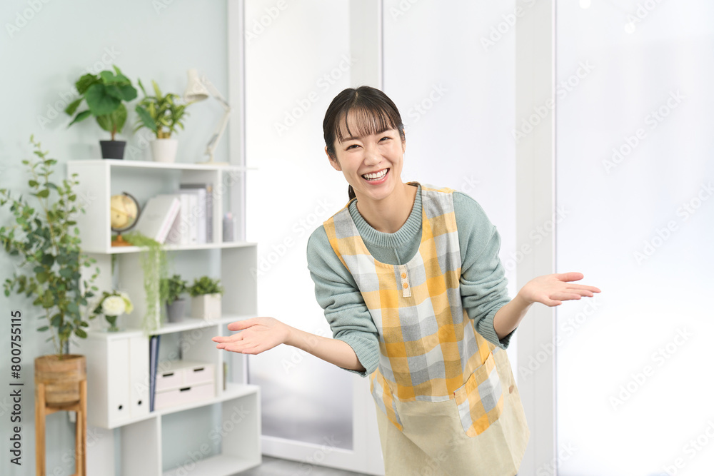 歓迎をするエプロンを着た女性 歓迎をするエプロンを着た女性