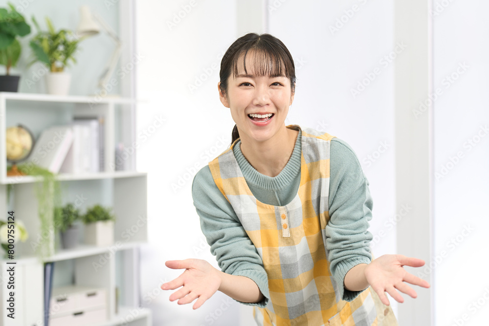 歓迎をするエプロンを着た女性 歓迎をするエプロンを着た女性