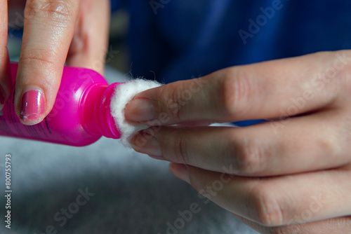 woman's hands using nail polish remover with cotton photo