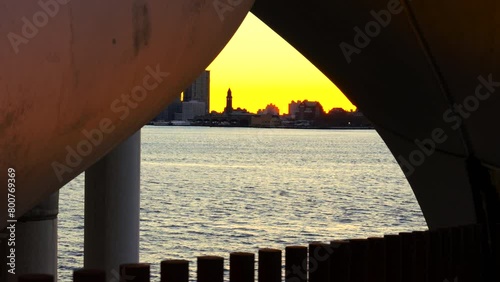 NEW YORK, NEW YORK USA – NOVEMBER 18: The Sunset Glow surrounds the New Jersey buildings along Hudson River view through pillars of the Little Island Park in West Village on November 18, 2023 in New Y photo